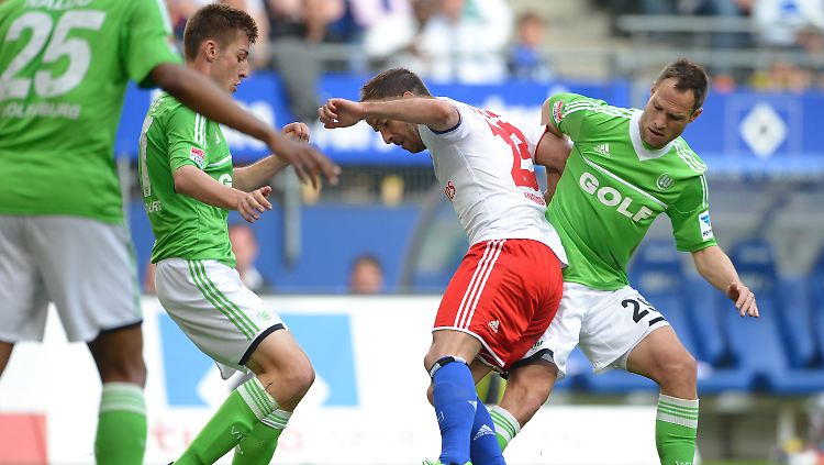 Wolfsburgs Robin Knoche (l) und Jan Polak (R) und Hamburgs Rafael van der Vaart kämpfen um den Ball.