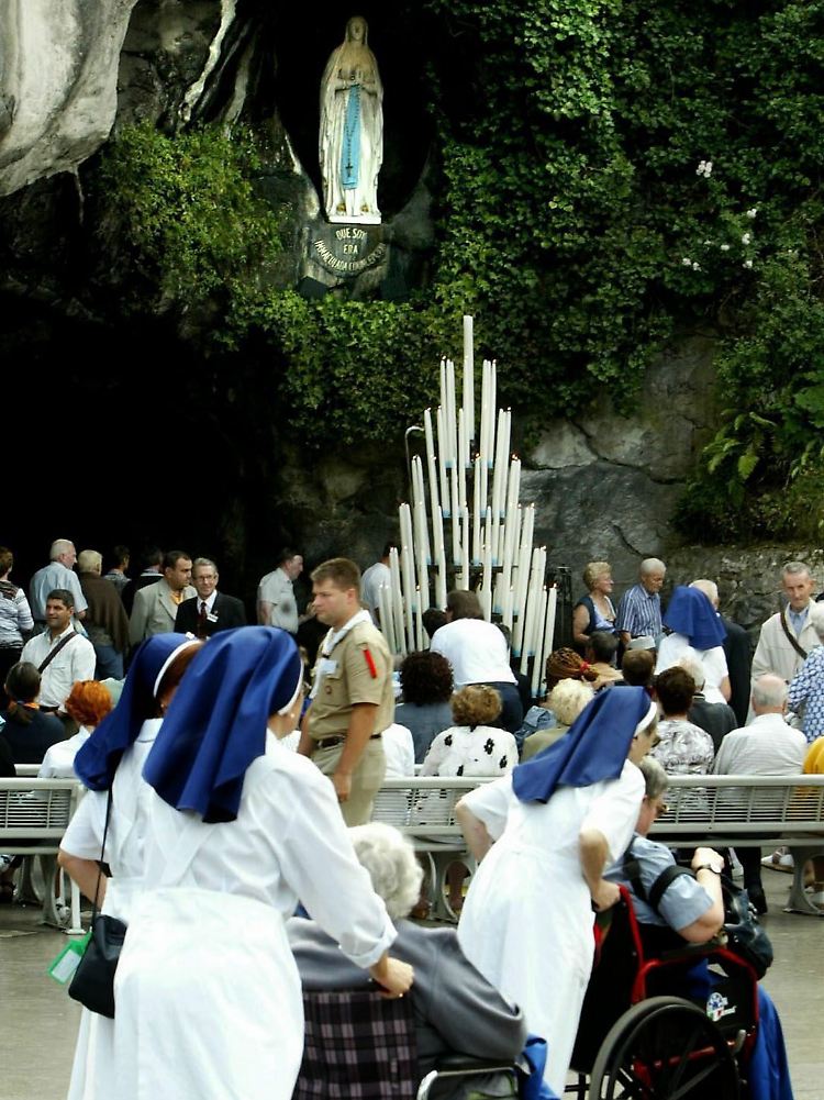 Pilger im Rollstuhl werden von Ordensschwestern zur Grotte von Massabielle im französischen Wallfahrtsort Lourdes gefahren.