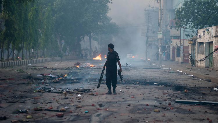 Der Tag danach: Ein Polizist patrouilliert durch eine verwüstete Straße in Dhaka.