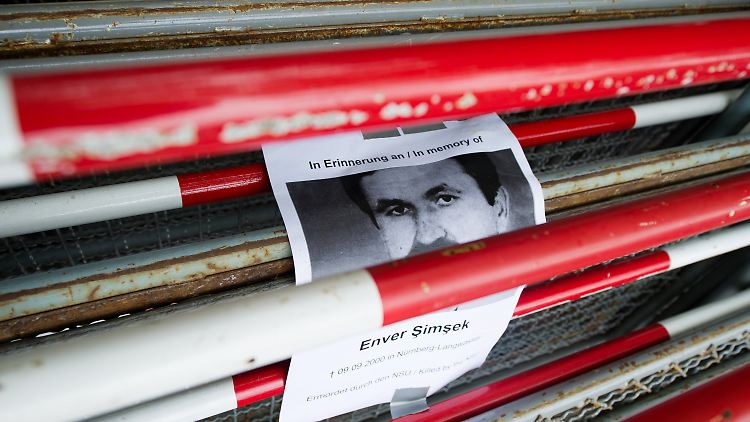 Ein Schild mit der Aufschrift "In Erinnerung an Enver Simsek" klebt an Absperrgitttern vor dem Oberlandesgericht München.