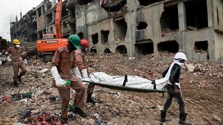 Bergungskräfte tragen eine Leiche vom Trümmerfeld - leider eine alltägliche Szene in diesen Tagen in Bangladesch.