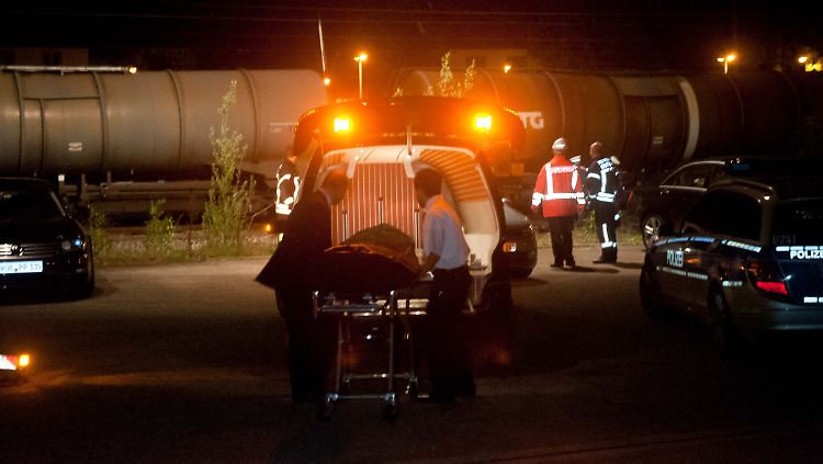 Vor abgestellten Kesselwagen wird ein Opfer abtransportiert.