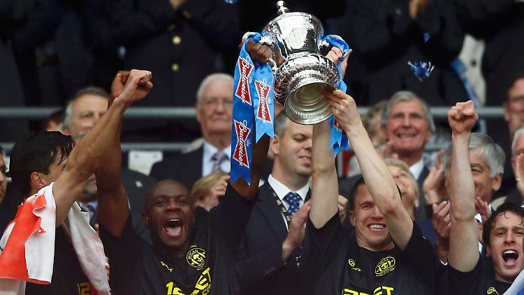 Emmerson Boyce (l) and Gary Caldwell feiern mit der Trophäe.