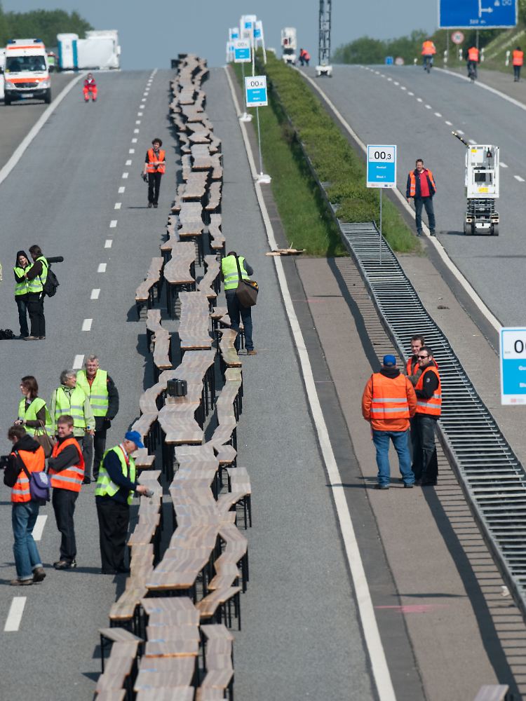 Bei der Generalprobe: Tischreihe bis zum Horizont auf der gesperrten Autobahn A540 bei Grevenbroich.