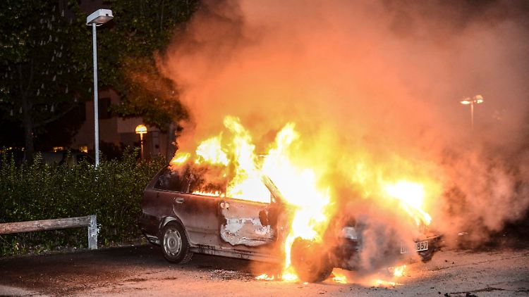 Feuerwehrleute löschen ein brennendes Auto. Auch in der Nacht zu Samstag brannten wieder Fahrzeuge. (Archivbild).