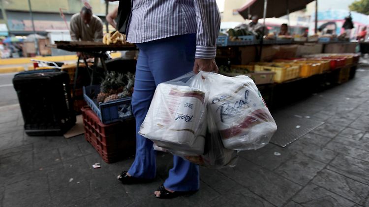 In Caracas verlässt eine Frau einen Laden, in dem sie Toilettenpapier gekauft hat.