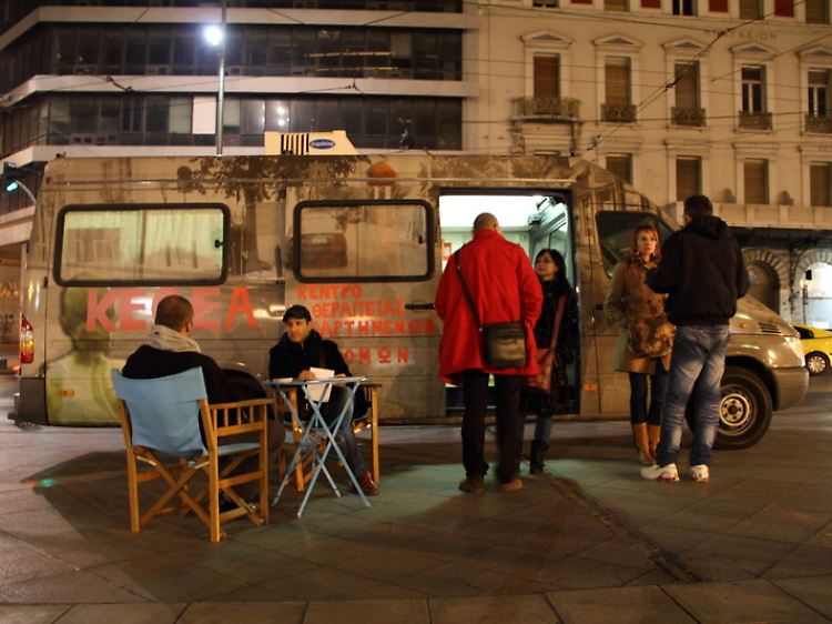 Mitarbeiter der Organisation Kethea stehen vor einem mobilen medizinischen Versorgungsbus