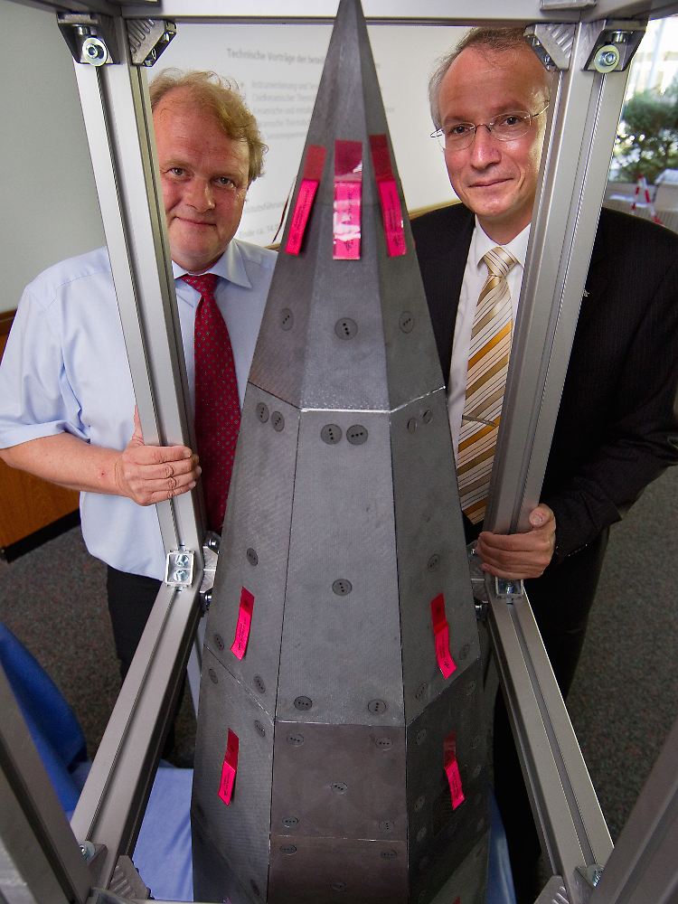 SHEFEX-Projektleiter Hendrik Weihs (links) und DLR-Direktor Heinz Voggenreiter stellen in Stuttgart die kantige Nutzlastspitze des neuen Testraumfahrzeugs "SHEFEX II" vor.