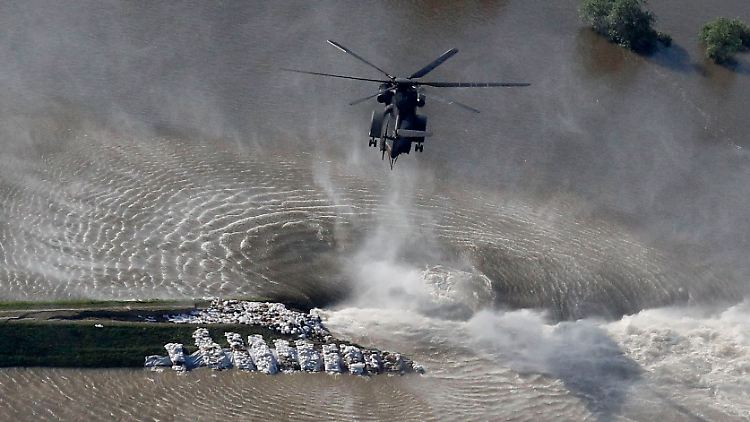 Mit Hubschraubern warf die Bundeswehr aus der Luft Säcke auf die Bruchstellen im Deich.