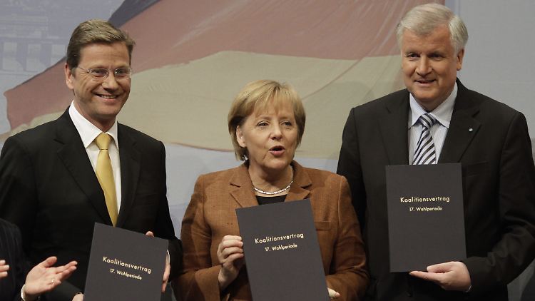 Der damalige FDP-Chef Westerwelle, Bundeskanzlerin Merkel und CSU-Chef Seehofer posieren am 26. Oktober 2009 mit den unterschrieben Koalitionsverträgen.