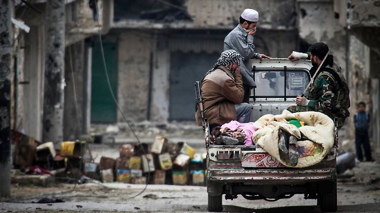 Rebellen in Aleppo. Auf der Trageflächen liegen zwei Tote, die sie in den Ruinen gefunden haben.