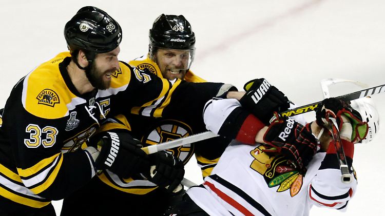 Dennis Seidenberg (2.v.l) bearbeitet mit Bruins-Teamkollege Zdeno Chara Gegensieler Bryan Bickell.