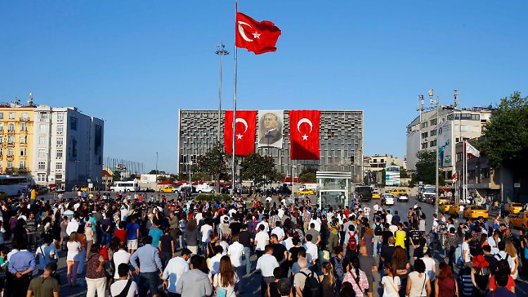 Den Blick fest auf Staatsgründer Mustafa Kemal Atatürk gerichtet stehen Hunderte Türken in stillem Protest auf dem Taksim-Platz.
