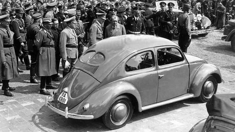 Nach der Grundsteinlegung besichtigt Adolf Hitler (M.) am 26.05.1938 im Volkswagenwerk in der Nähe von Fallersleben einen Volkswagen "Käfer". Rechts neben ihm Ferdinand Porsche.