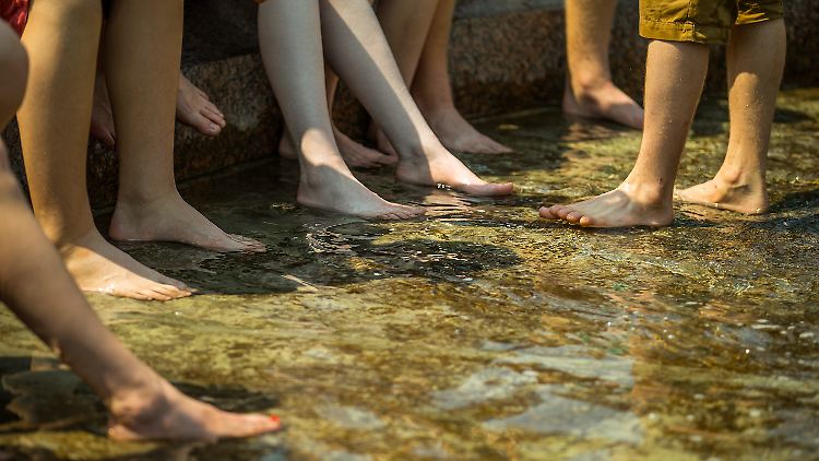 Die Hitze hat Berlin fest im Griff: Touristen kühlen im Neptunbrunnen ihre Füße. Im Mai war es nicht so heiß in Deutschland, dafür besonders nass.