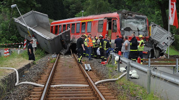 Helfer bergen die Trümmer des Personenzuges und des Sattelschleppers.