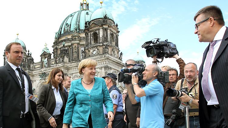 Der Dom als Kulisse: Angela Merkel auf dem Weg in die "Humboldt-Box", die über den Neubau des Schlosses informiert.