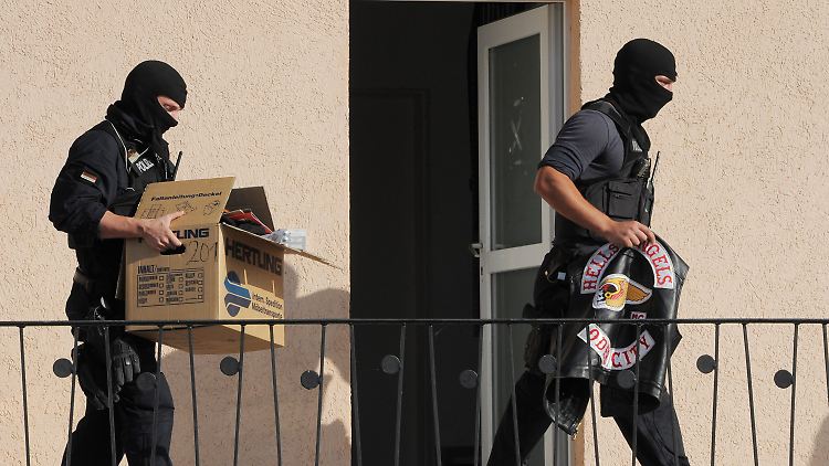 Polizeibeamte tragen beschlagnahmte Gegenstände aus einem Haus in Fürstenwalde.