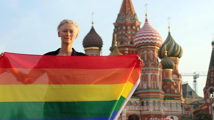 Tilda Swinton mit Regenbogenfahne vor der Basilius-Kathedrale auf dem Roten Platz in Moskau.