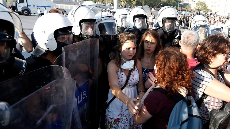 Polizisten umringen eine junge Frau, die gegen die Regierung Erdogan demonstriert. 