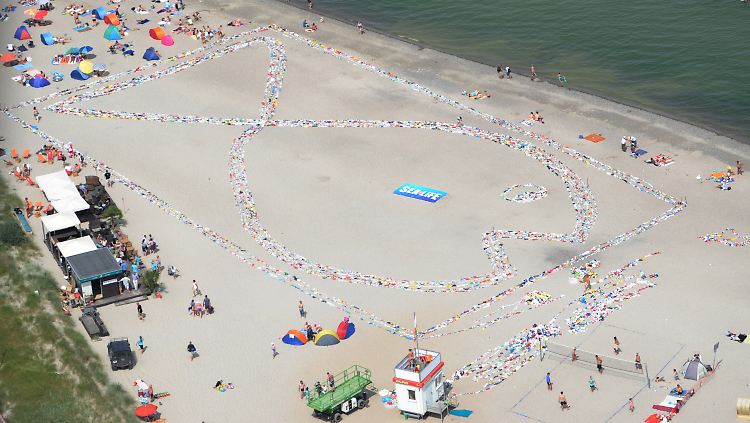 Zusammengeknotete Plastiktüten bilden am Strand von Niendorf einen gigantischen Fisch.