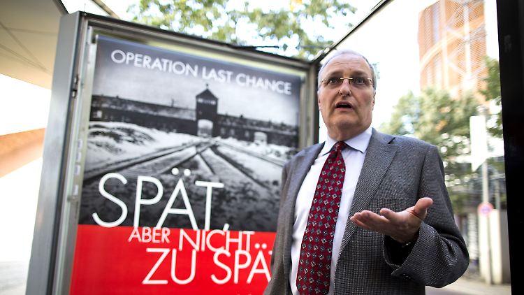 Efraim Zuroff vor dem Suchplakat auf dem Potsdamer Platz.