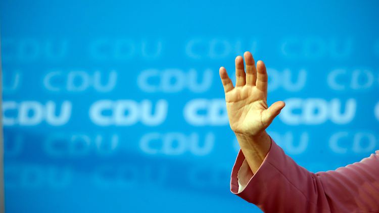 Angela Merkel winkt bei einer Rede im Ostseebad Binz.