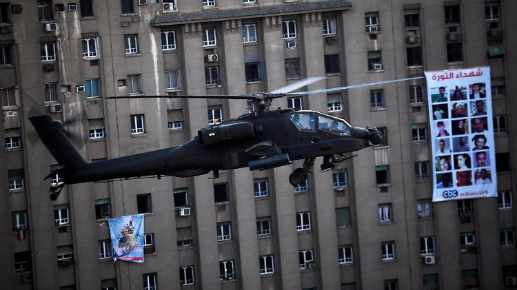 Ein Apache des ägyptischen Militärs patrouilliert über dem Tahrirplatz in Kairo.