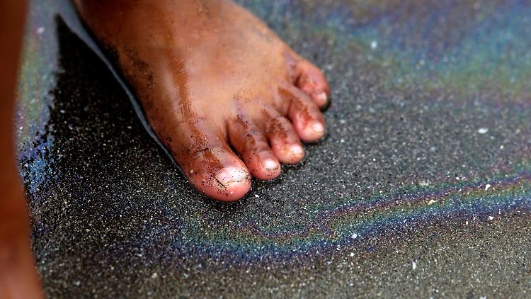 Schillernder Regenbogeneffekt auf schwarzem Sand: Südlich von Manila spülen die Wellen Reste eines mysteriösen Diesel-Teppichs an die Küste der Philippinen.