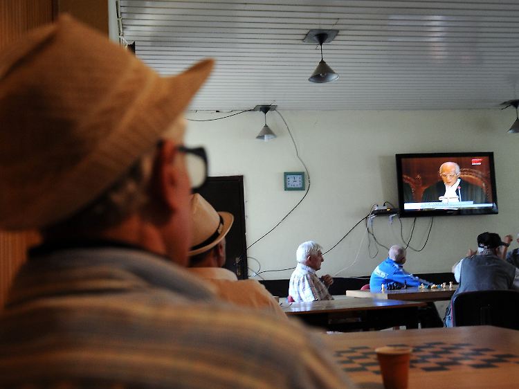 In Pristina verfolgen Kosovo-Albaner den Gerichtsentscheid im Fernsehen.