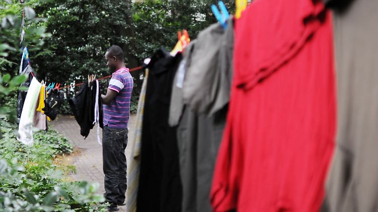 Ein afrikanischer Flüchtling hängt im Garten der Hamburger St.-Pauli-Kirche seine Wäsche auf.