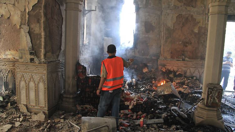 In Kairo filmt ein Ägypter die Überreste einer abgebrannten Moschee.