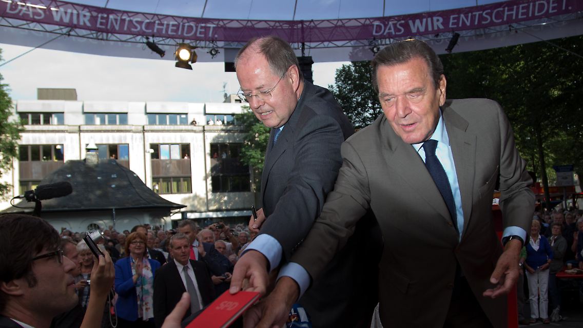 Steinbrück und Schröder stehen gemeinsam auf der Bühne.