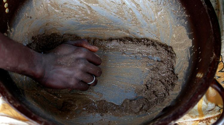 Ein Minenarbeiter in Nigeria wäscht Goldstaub aus. 