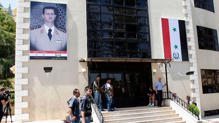 Journalisten und Sicherheitspersonal vor dem Yousef al-Azma Militärkrankenhaus in der syrischen Hauptstadt Damaskus. UN-Mitarbeiter besuchen mutmaßliche Opfer eines Giftgasangriffs.