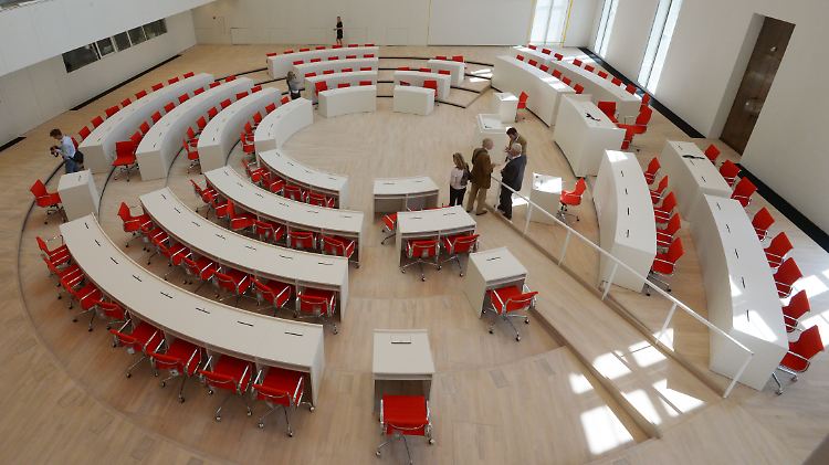 Die roten Stühle sind die einzigen Farbtupfer in dem ansonsten in Weiß gehaltenen Plenarsaal.