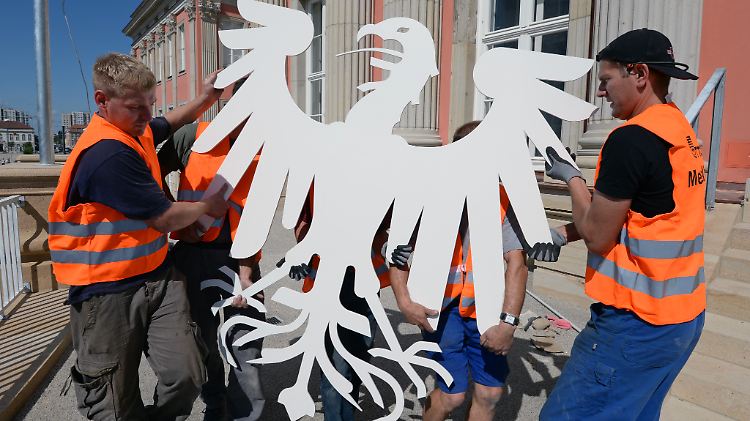 Das neue hoheitliche Wappen des Landtags, der Adler, wird in das Landtagsgebäude getragen.