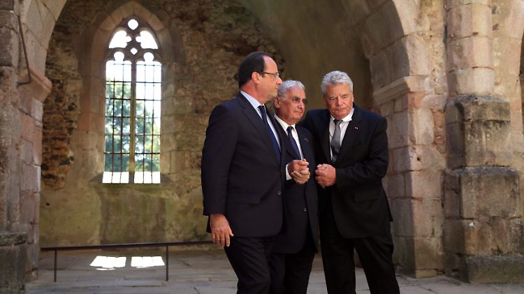 Hollande und Gauck stützen Hébras in der Ruine der ausgebrannten Kirche von Oradour.