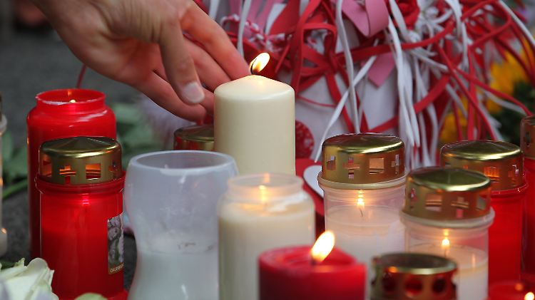 Tausende Menschen kommen zum Unglücksort und legen Blumen nieder, zünden Kerzen an.