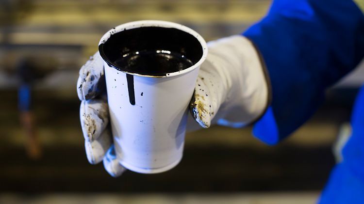 Stark, schwarz - aber, Halt!, kein Kaffee: In Fort McMurray präsentiert ein Mitarbeiter eine Probe Schweröl in die Kamera.
