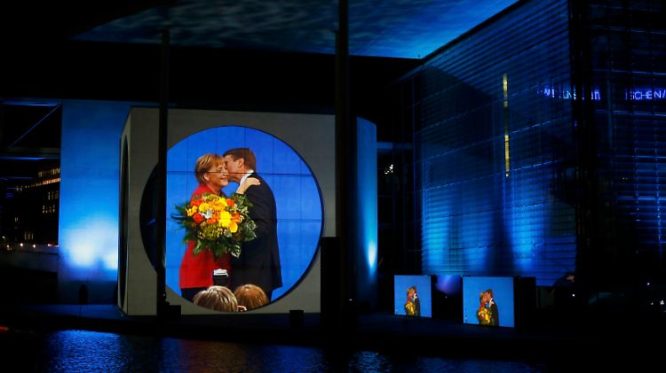 Bundestagswahl 2013: An der Spree wirft ein leistungsstarker Beamer Live-Bilder einer glücklichen Wahlsiegerin an die Fassade des Marie-Elisabeth-Lüders-Hauses.