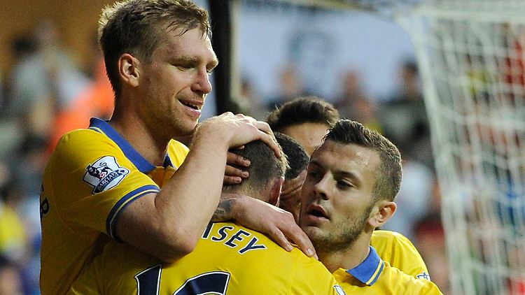 Per Mertesacker (l.) feiert mit Jack Wilsher (r.) das Tor von Aaron Ramsey (M.).