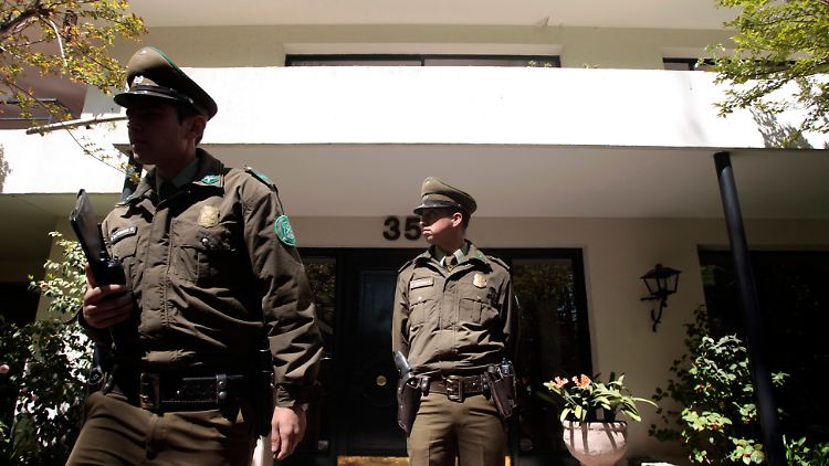 Polizisten stehen Wache vor dem Haus von Mena.