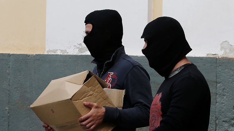 Polizisten der Anti-Terror-Abwehr tragen Material, das die griechischen Rechtsextremen belastet.