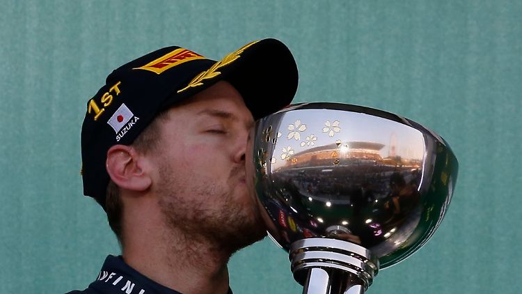 Sebastian Vettel herzt den Siegerpokal in Suzuka.