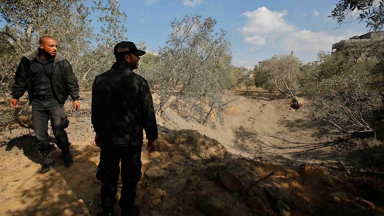 Palästinensische Polizisten schauen sich den Ort an, an dem eine israelische Rakete einschlug.