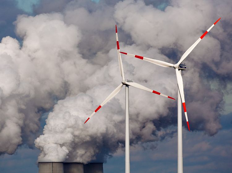 Zwei grundverschiedene Energiequellen: Windräder vor den Kühltürmen des Braunkohlekraftwerks der Vattenfall Europe AG im brandenburgischen Jänschwalde.