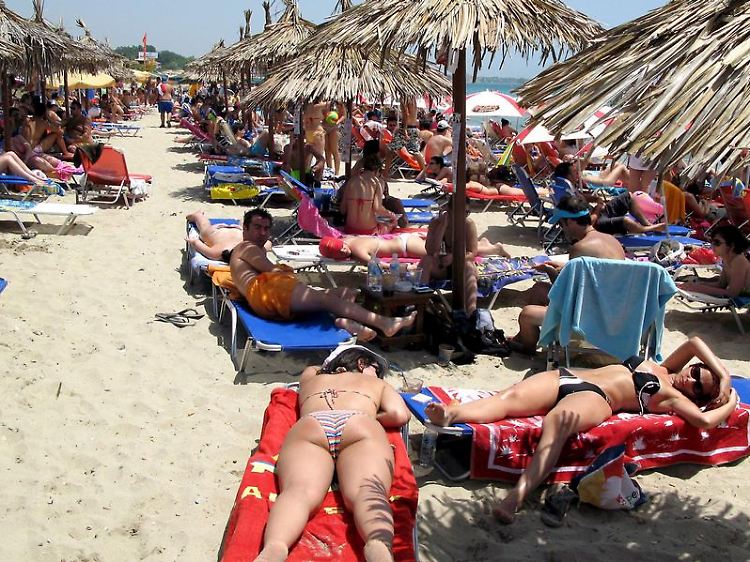 Touristen am Strand von Thessaloniki: Für Pauschalreisende kann der Griechenland-Urlaub - vorerst - entspannt weitergehen.