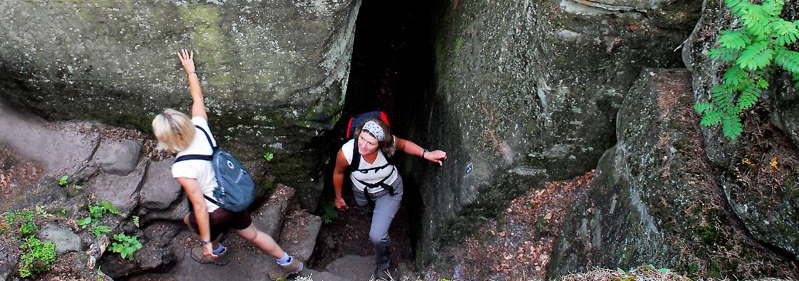 Ganz schön eng: Auf dem Mullerthal Trail müssen sich Wanderer auch mal durch schmale Felsspalten zwängen.