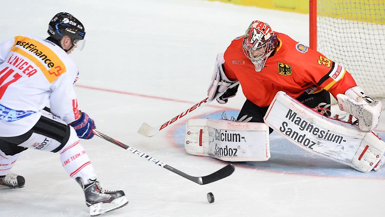 Die deutsche Torhüter Danny Aus den Birken (r.) und der Schweizer Michael Liniger kämpfen im Penaltyschießen um den Puck.